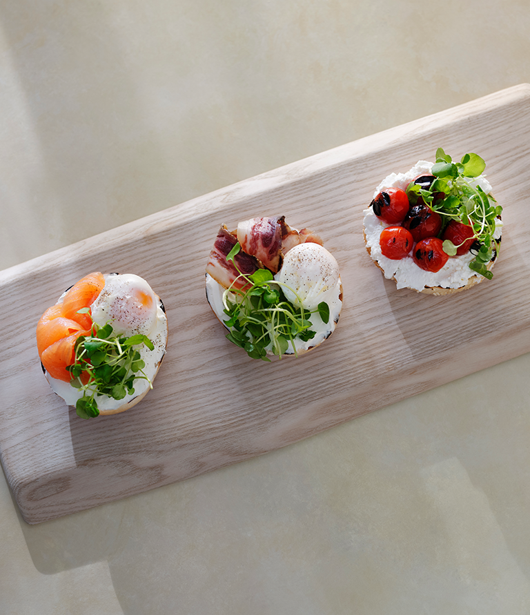 a wooden tray topped with three small sandwiches.
