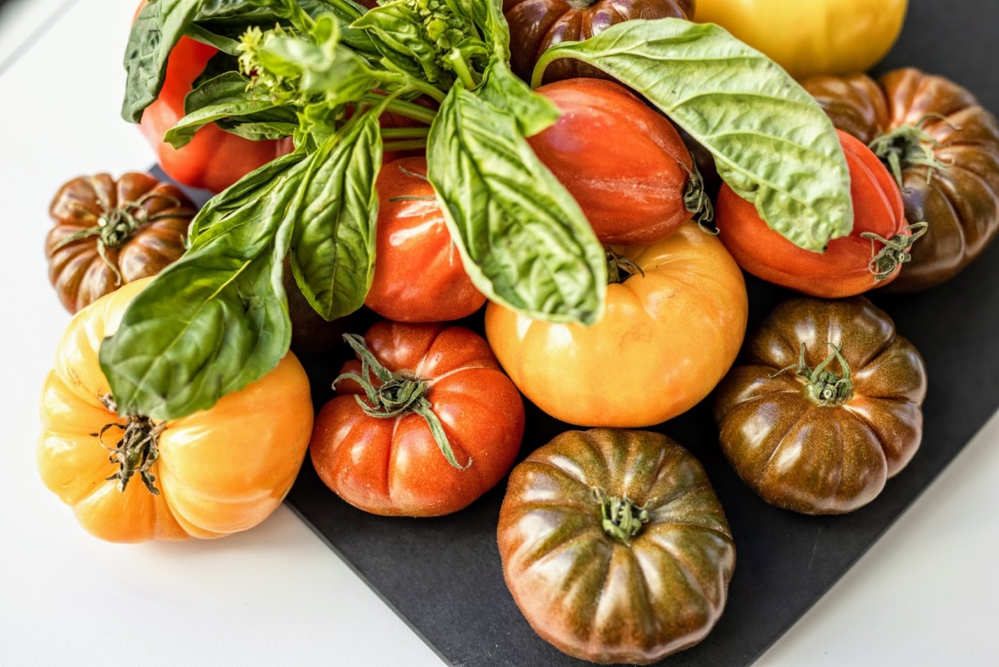 a pile of different types of tomatoes on a table.