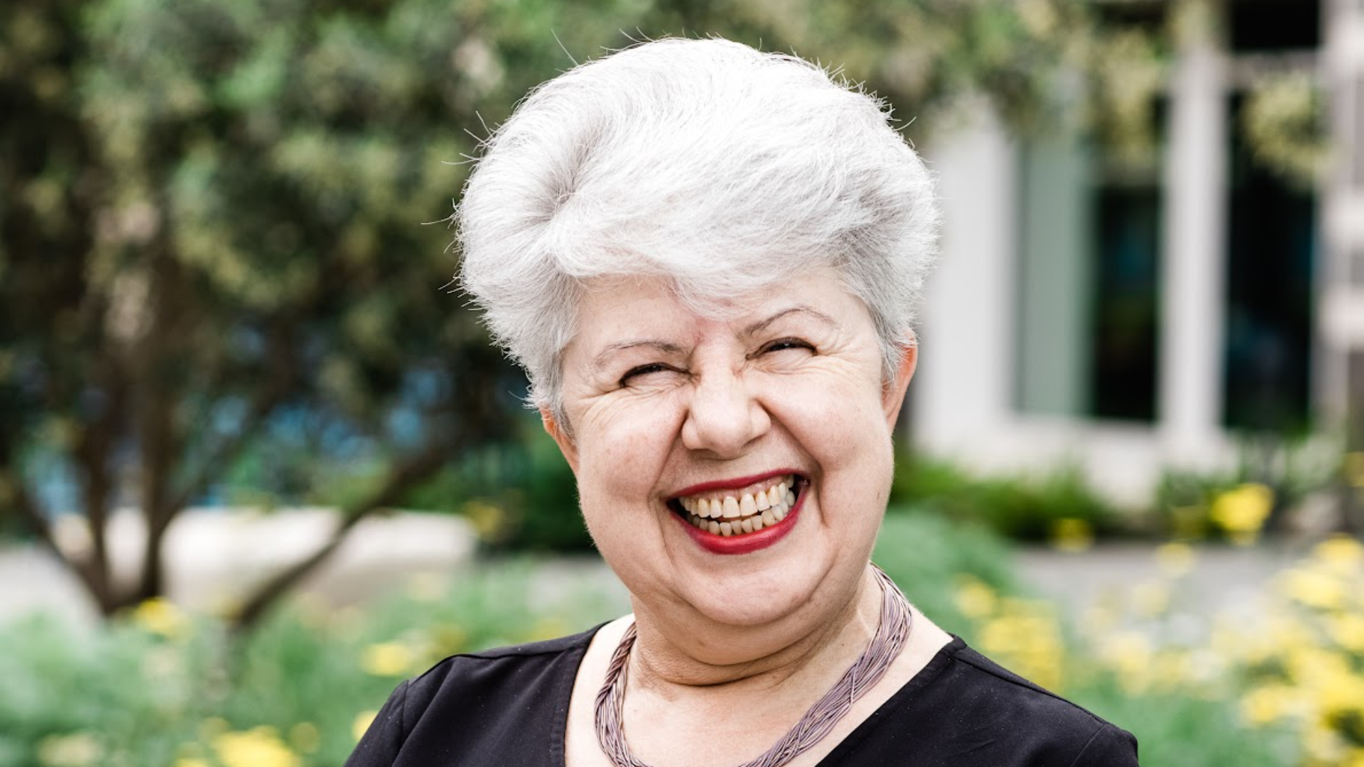 a woman with white hair and a smile on her face.
