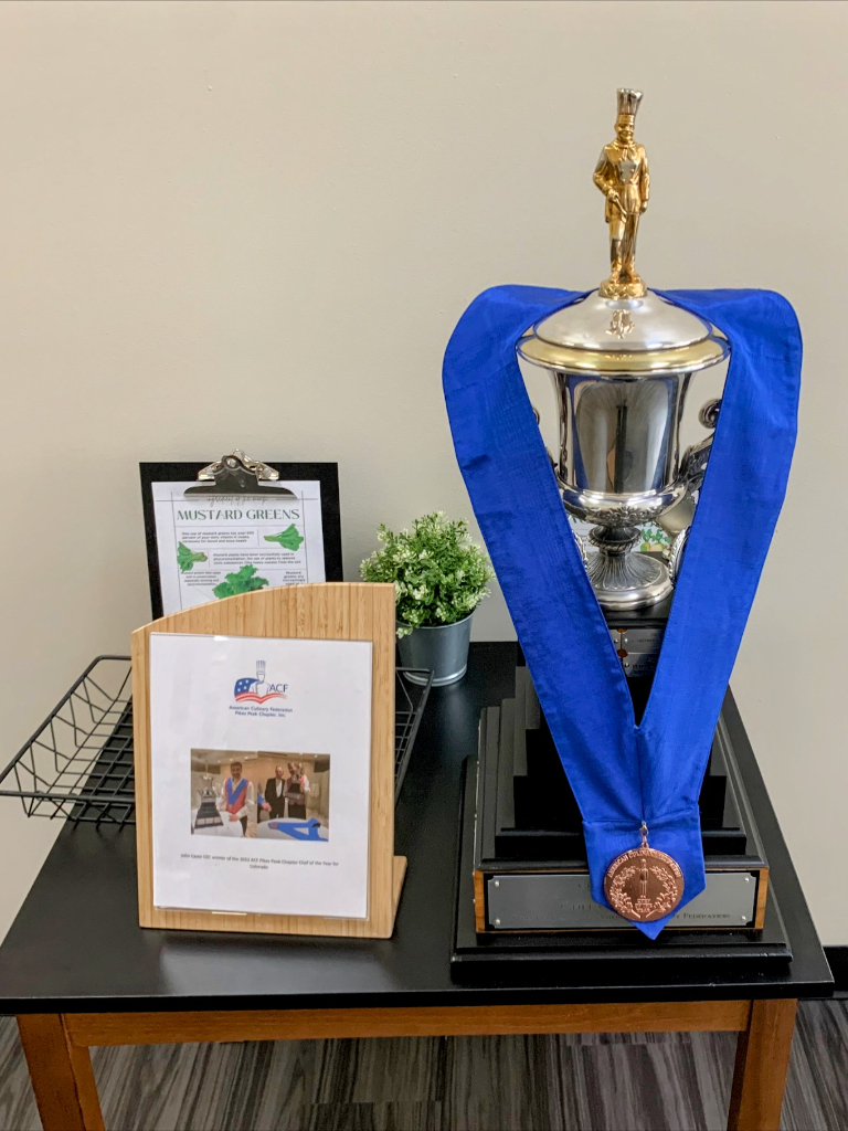 a trophy sitting on top of a table next to a plaque.